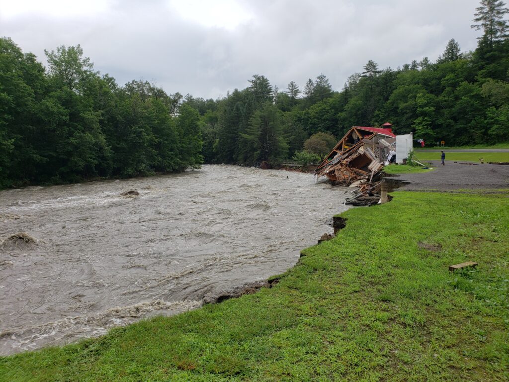 House falling into flooded river Vermont July floods 2023