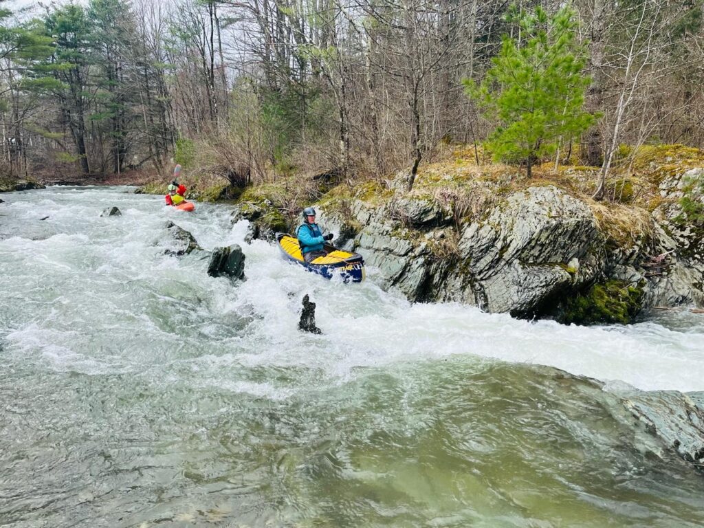 A canoer and kayaker navigate "Flat Rock" rapid on the Upper Poultney River Vermont Whitewater